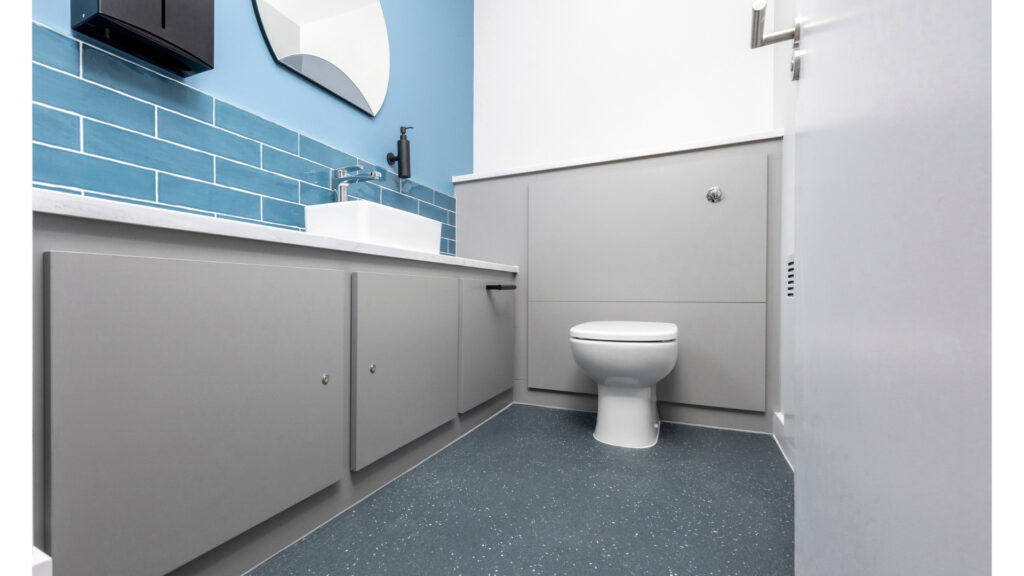 Grey universal toilet/ superloo with solid surface vanity top on the left hand side